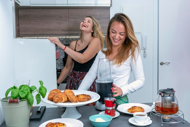 Nettes lesbisches Paar, das glücklich das Frühstück LGTB-Konzept zubereitet