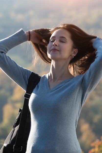 Foto nettes mädchen berührt haar natürliches langes haar vertikaler rahmen des porträts