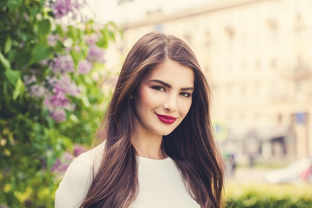 Nettes Mädchen Brunette im Freien am sonnigen Tag des Sommers