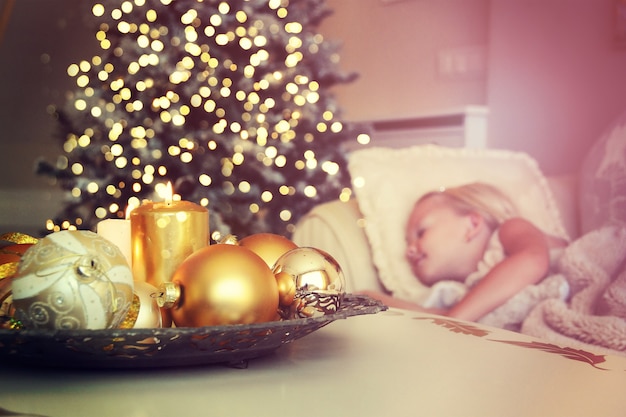 Foto nettes mädchen, das auf dem boden unter dem weihnachtsbaum schläft