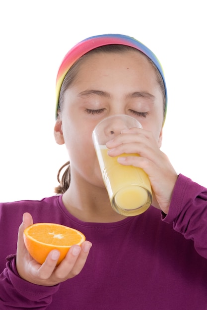 Nettes Mädchen, das einen Saft der Orange auf einem über weißen Hintergrund trinkt