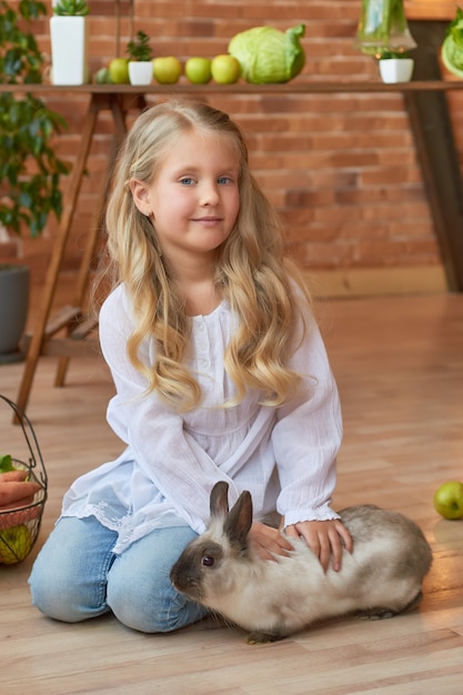 Nettes Mädchen, das mit Kaninchen spielt