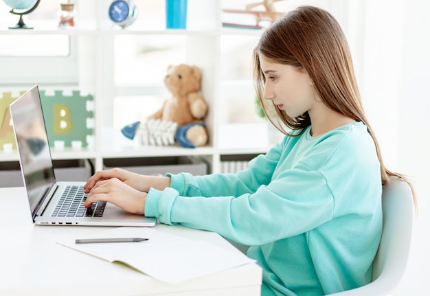Nettes Mädchen, das mit Laptop, Online-Ausbildung studiert