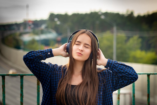 Nettes Mädchen, das Musik mit Kopfhörern auf einer Stadtstraße hört