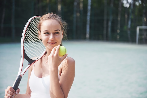 Nettes Mädchen, das Tennis spielt und aufwirft