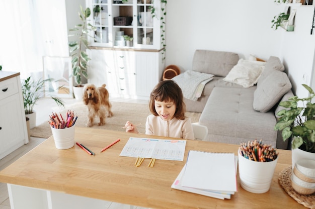 Nettes Mädchen im Vorschulalter, das zu Hause lernt Homeschooling Fernunterricht für Kinder