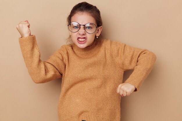 Nettes Mädchen in einem Pullover und posiert mit Brille isolierter Hintergrund