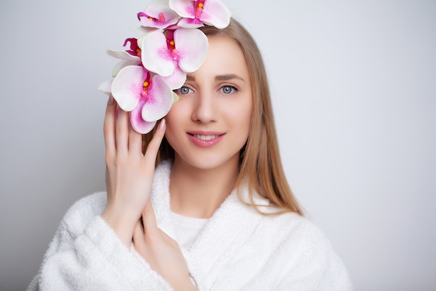 Nettes Mädchen mit Blumen nach dem Duschen