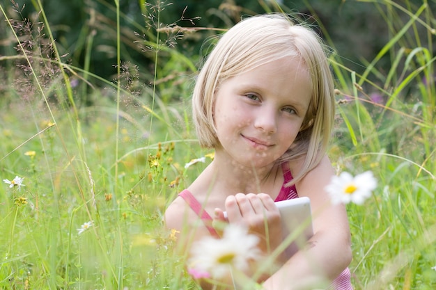 Foto nettes mädchen mit e-reader im freien