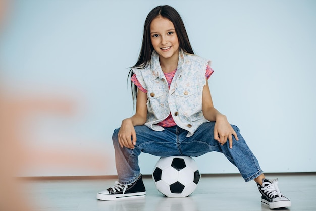 Nettes Mädchen mit Fußballball im Studio