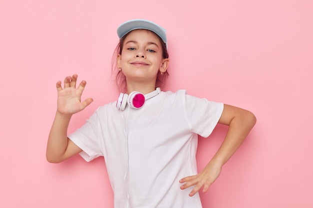 Nettes Mädchen mit Kopfhörern, das unverändert die Emotionen der Kindheit aufwirft
