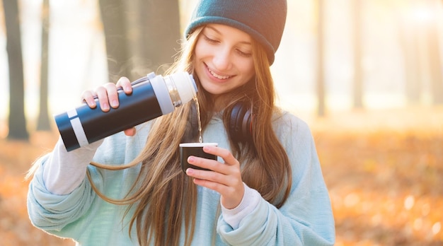 Foto nettes mädchen mit thermoskanne