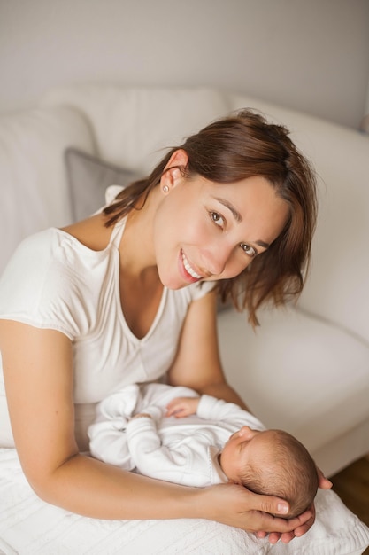 Nettes Neugeborenes Baby, das in den Armen der Mutter schläft. Mutterschaft.