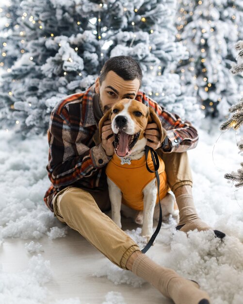 Nettes Neujahrsfoto eines Mannes und seines Hundes Festliche Porträtfotos eines Hundes in Neujahrsdekorationen