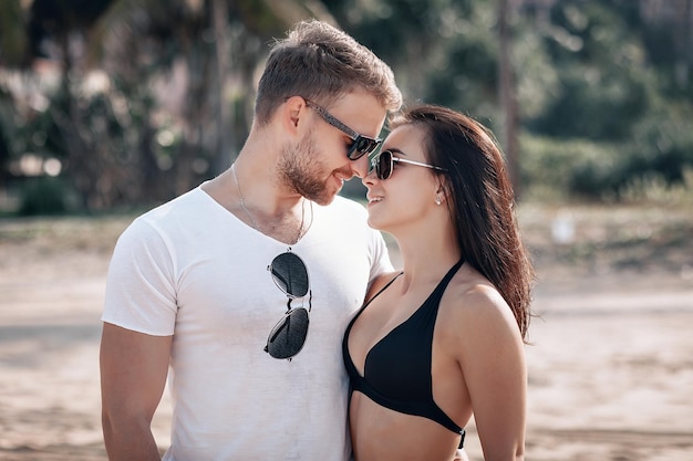 Nettes Paar, das am exotischen sonnigen Strand steht, umarmt, liebt und Romantik.