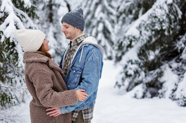 Nettes Paar, das sich im Winterwald oder Park ansieht