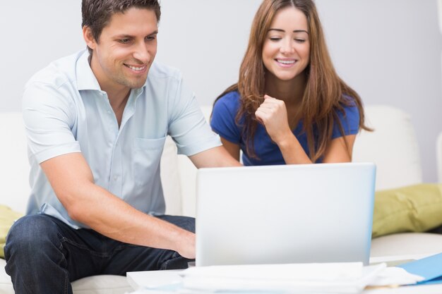 Nettes Paar, das zu Hause Laptop verwendet