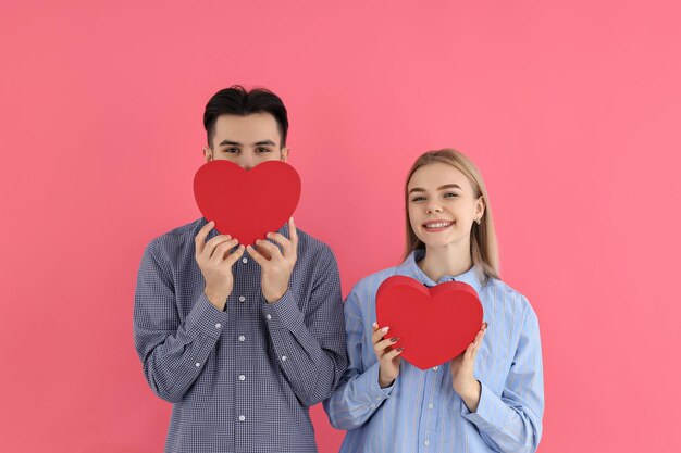 Nettes Paar mit Herzen auf rosa Hintergrund