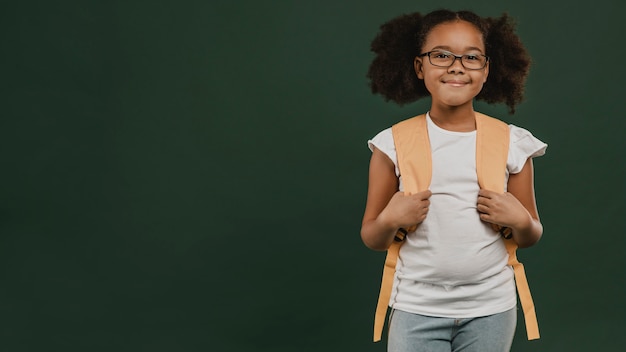 Nettes Schulmädchen, das ihren Rucksack hält