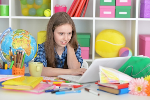 Nettes Studentenmädchen im Unterricht mit Laptop und Tee