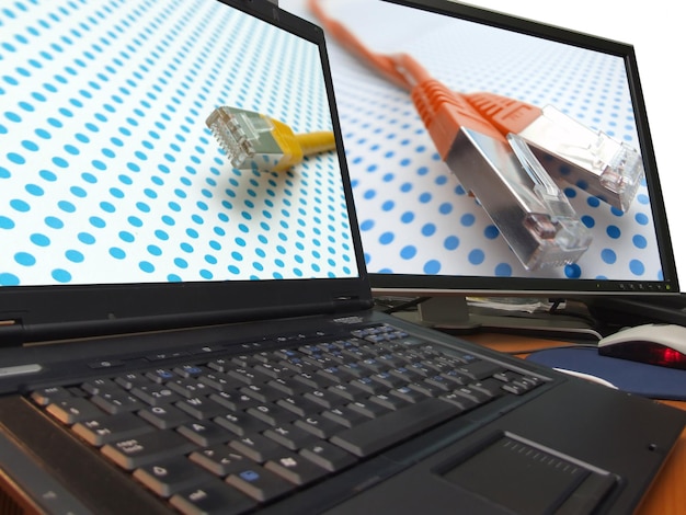 Foto netzwerkkabel am laptop und großem breitbildschirm