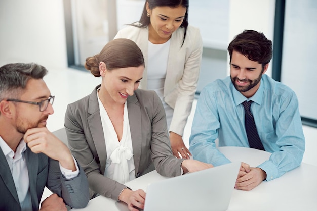 Neudefinition ihres Vorschlags Schnappschuss einer Gruppe von Geschäftsleuten, die in einem modernen Büro an einem Laptop zusammenarbeiten