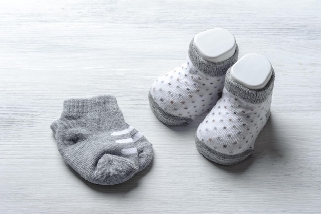 Neue Babysocken auf weißem Holzbrett Neugeborenen- und Babykonzept