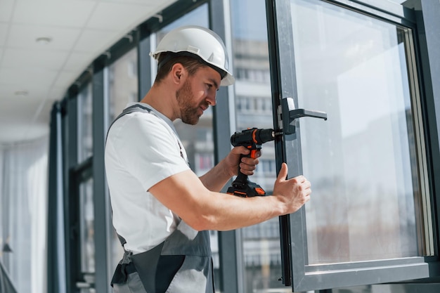 Neue Fenster einbauen Nahaufnahme des Handwerkers, der im modernen Raum drinnen arbeitet