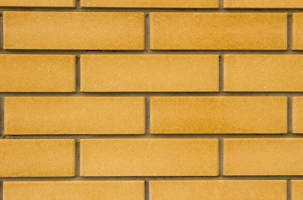 Neue flache Backsteinmauer in beige Farbe mit tiefen Nähten.