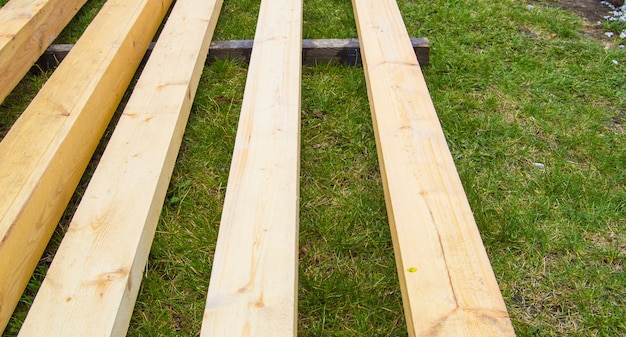 Neue Holzbretter auf dem Gras. Bauholz für den Vorstadtbau.