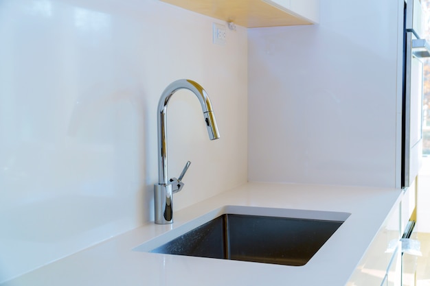Neue moderne weiße Küche mit eingebautem Chromwasserhahn