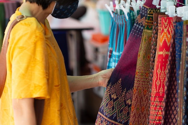 Neue normale Reisende wählen Thailands traditionelle Baumwollkleidung im ländlichen Laden aus