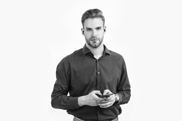 Neue Technologie erfolgreicher unrasierter Kerl Typ Nachricht Online-Geschäft Gutaussehender Mann mit drahtlosen Kopfhörern und Telefon Geschäftsmann verwendet Bluetooth-Kopfhörer mit Smartphone-Bluetooth-Headset-Gerät
