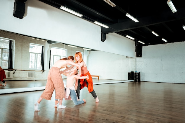 Neue Züge. Zwei Schüler einer Tanzschule und ihr Lehrer in Jeans arbeiten an neuen Bewegungen