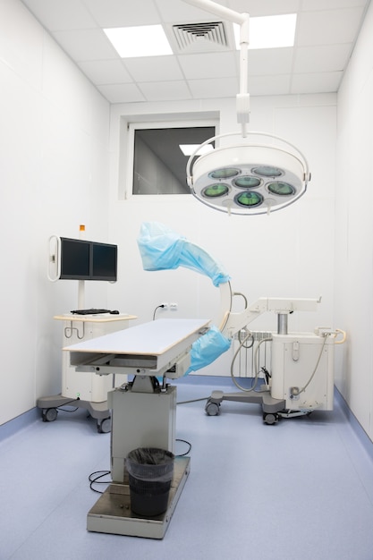 Neues Fluoroskop / C-Arm in Schutzhülle mit Fernseher zur Ausstrahlung in moderner Tierklinik, Operationssaal