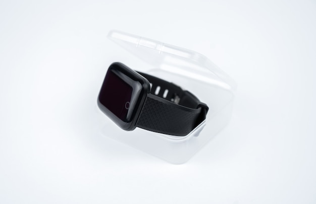 Neues intelligentes Fitnessarmband mit leerem schwarzen Bildschirm in einer transparenten Plastikbox