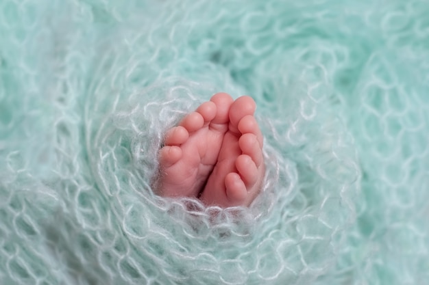 Foto neugeborene babybeine auf einem blauen hintergrund