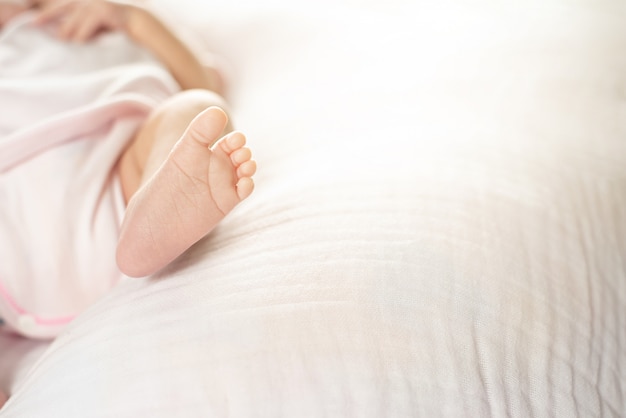 Neugeborene Babyfüße auf einer weißen Decke - kleine Babyfußnahaufnahme