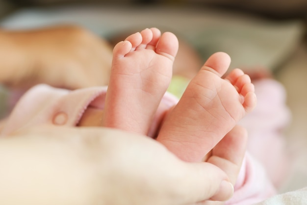Neugeborene Babyfüße in der Mutterhand
