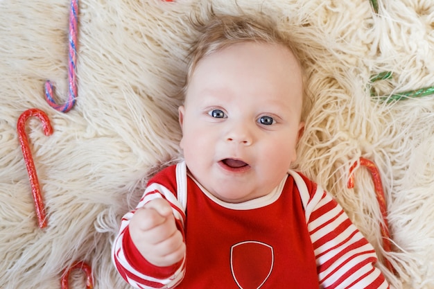 Neugeborene bis zu fünf Monaten im roten Pyjama liegen unter mehrfarbigen Konferenzteilnehmern