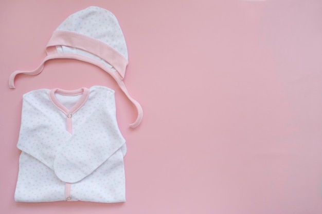 Neugeborene Kleidung auf rosa Hintergrund, Kopierraum, Draufsicht