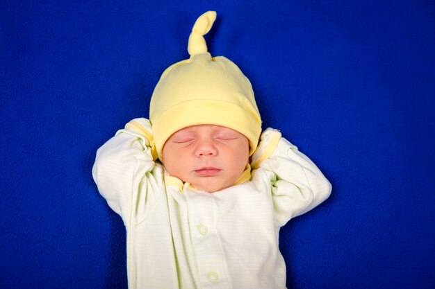 Neugeborener kleiner Junge, der auf einer blauen Decke schläft. Babyartikelverpackung