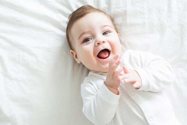 Foto neugeborener kleinkindjunge, der auf dem bett lacht
