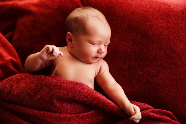 Neugeborenes Baby auf einer roten Oberfläche