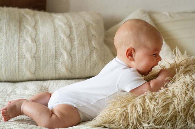 Neugeborenes Baby, das auf dem Bett liegt