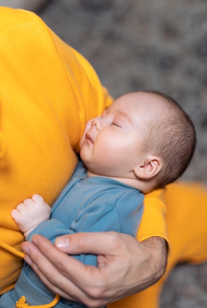 Neugeborenes Baby in den Armen des Vaters Closeup Portrait von niedlichen süßen Baby Gesicht Neugeborenes gesundes Kind schläft in männlichen Armen