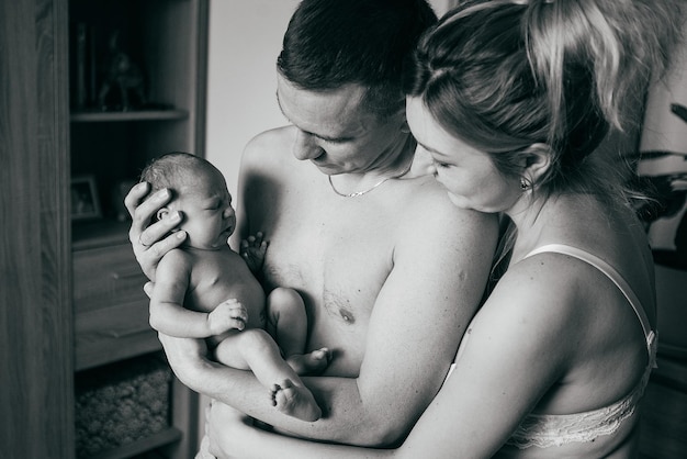 Neugeborenes Baby in den Händen der Eltern