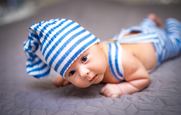 Neugeborenes Baby in hellblauer Kleidung Baby liegt auf dem Bauch und macht ein süßes Gesicht