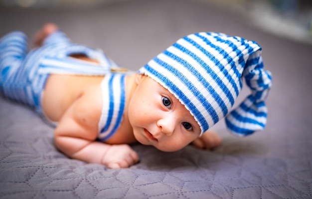 Neugeborenes Baby in hellblauer Kleidung Baby liegt auf dem Bauch und macht ein süßes Gesicht