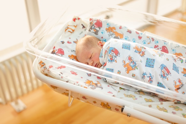 Neugeborenes Baby in seinem Babymantel im Krankenhaus nach der Entbindung.